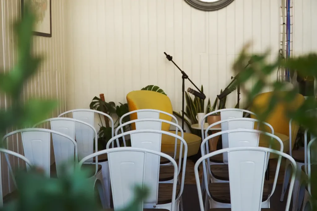 Audience chairs facing the yellow armchairs and microphones set up for a live recording