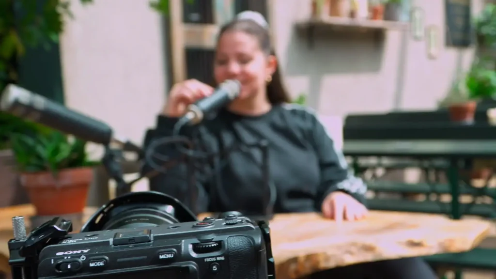 A Sony camera framing a guest speaking into a microphone on a Pod-To-Go location shoot