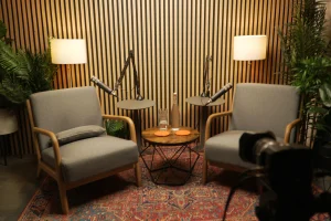Two grey chairs in a podcast studio with a blackmagic G2 camera in the foreground